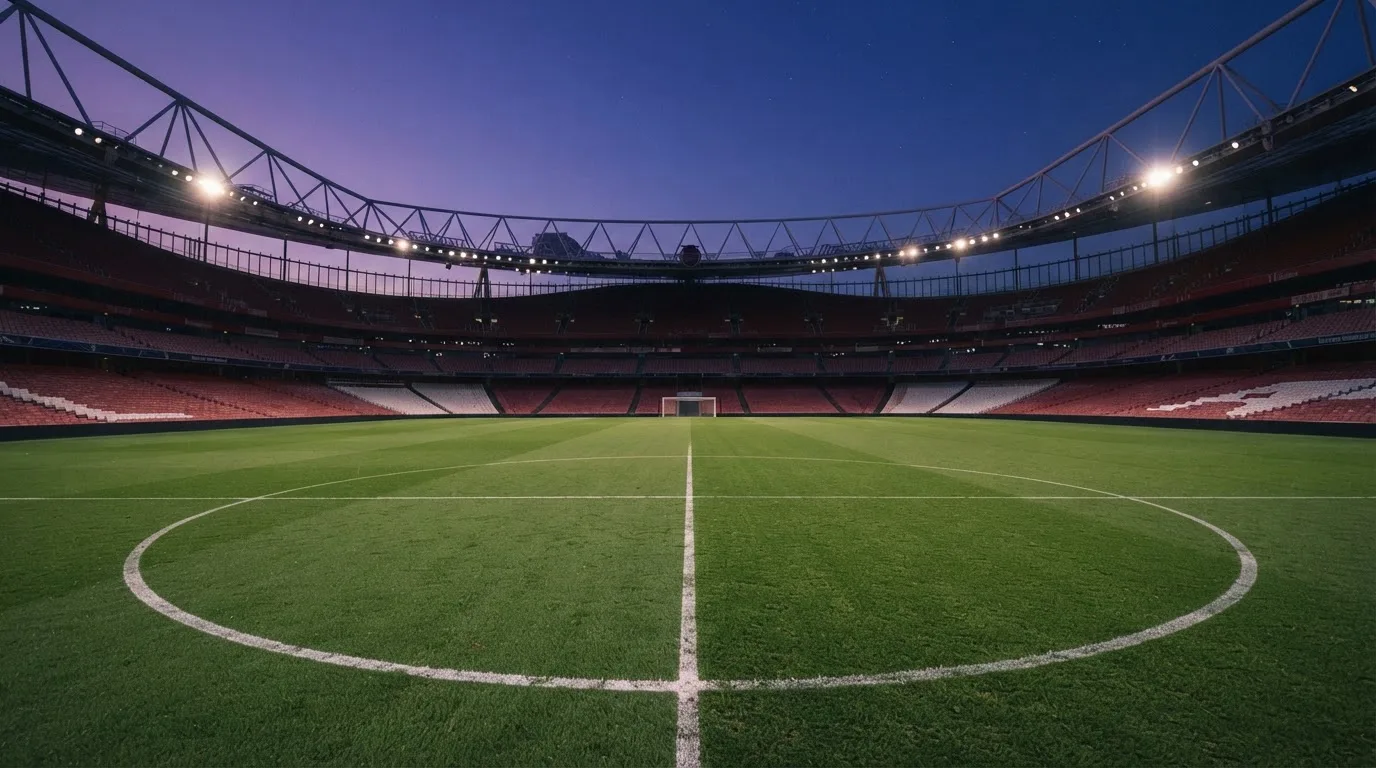 Een leeg voetbalstadion met lichtmasten bij schemering